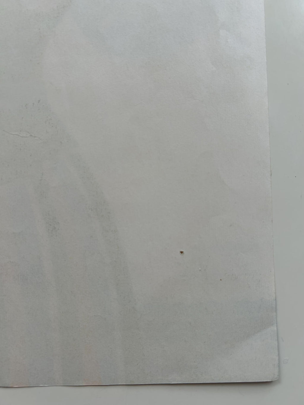 White paper with a small black mark on a white background