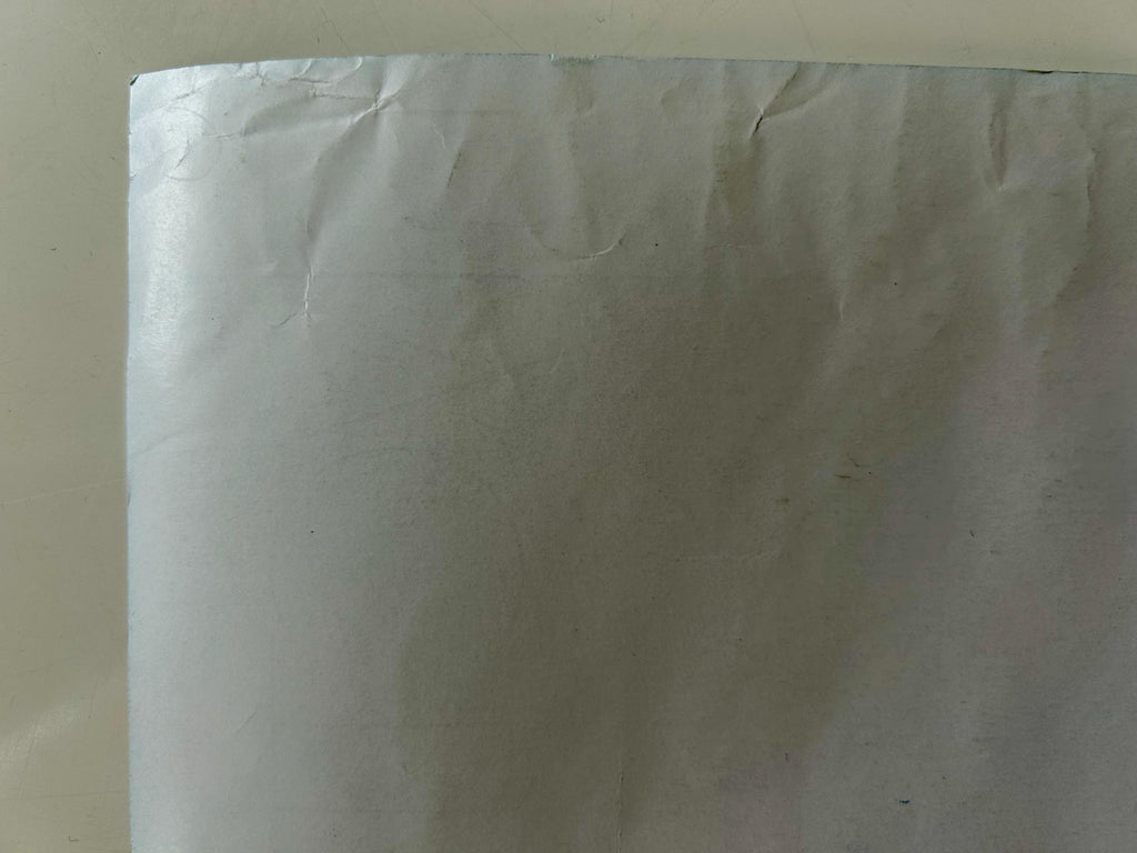 Close-up of a white sheet with visible texture and folds on a beige background
