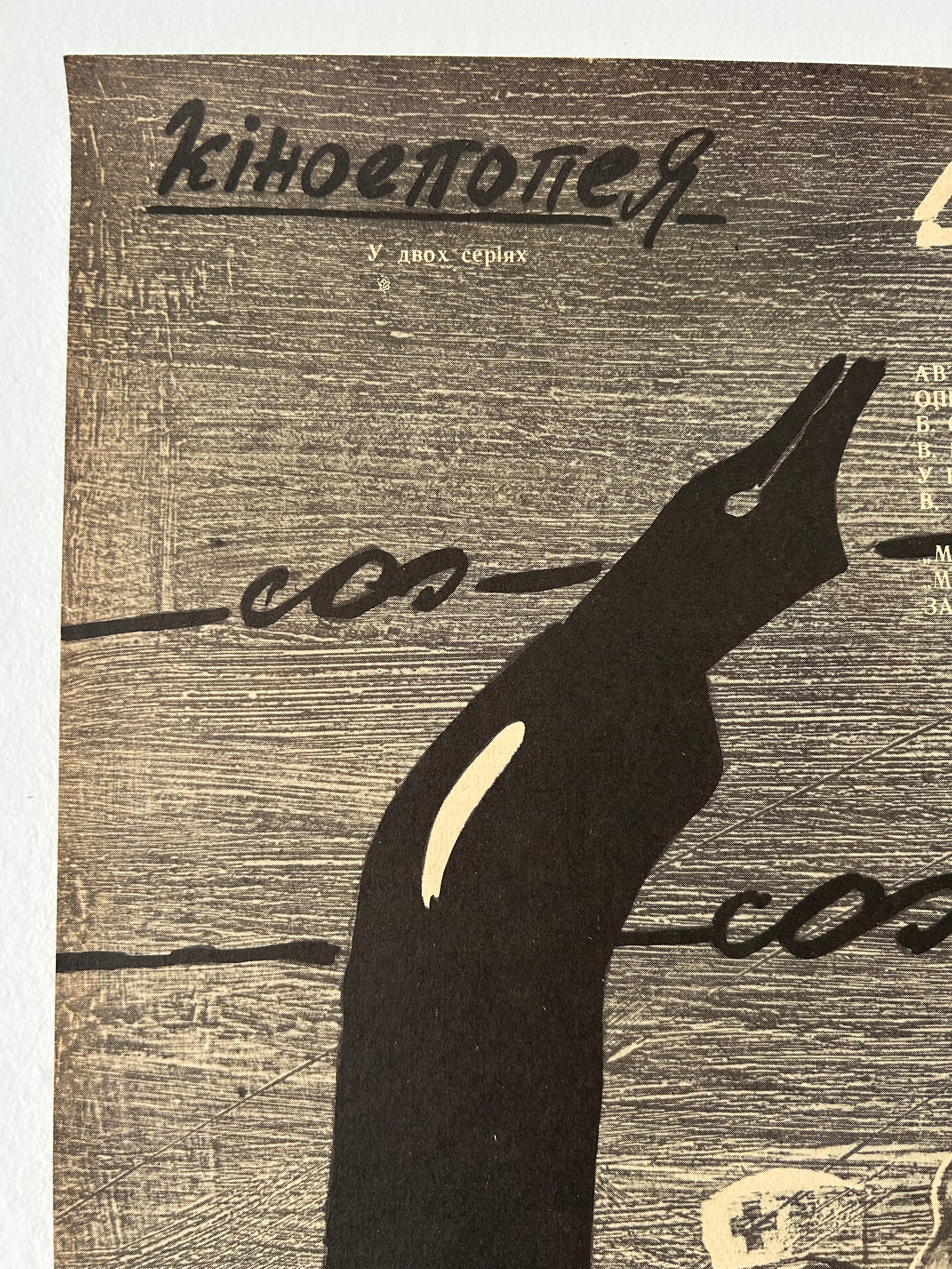 Black silhouette of a stylized ink pen on a textured brown background 