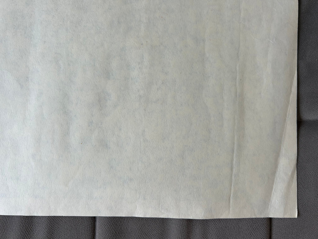 Close-up of a textured gray fabric with a subtle pattern on a dark background