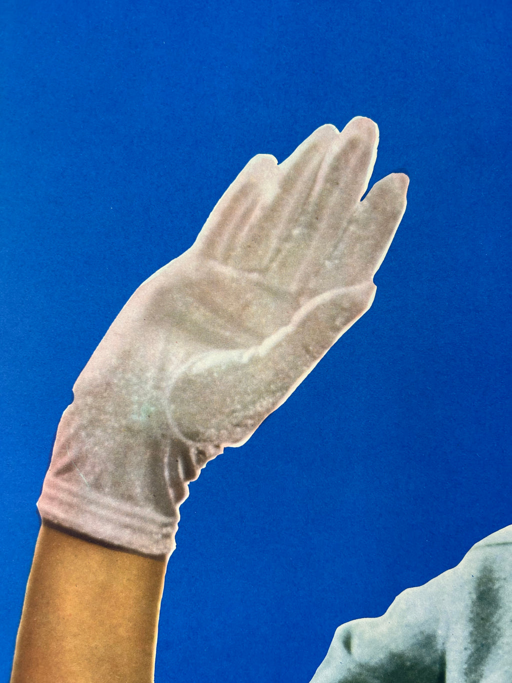 White glove on a person's hand against a blue background