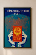 Framed poster with a world map and hands holding USSR Constitution, featuring text and a logo.