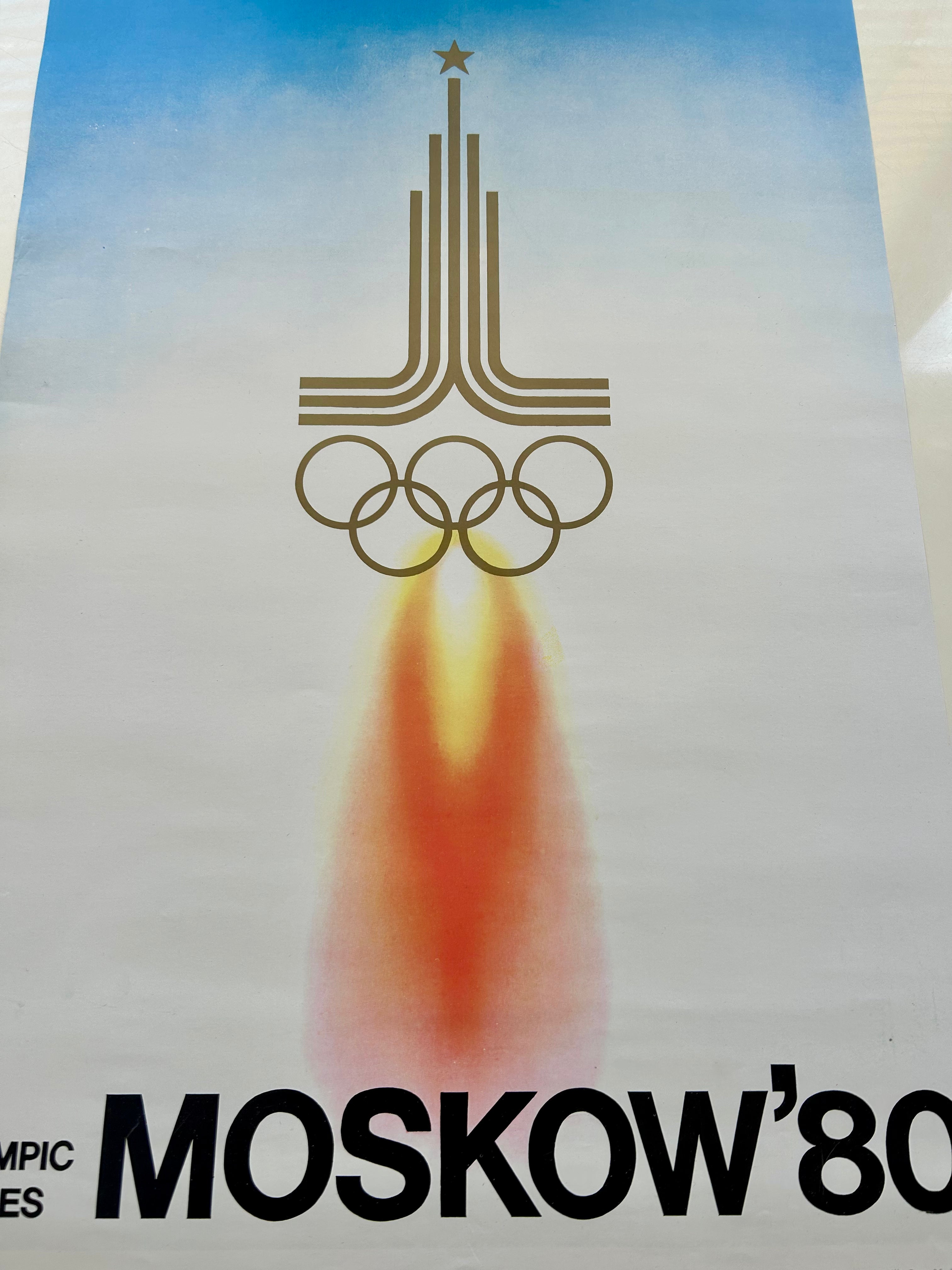 a fragment of  poster of the 1980 Moscow Olympics with a rocket and Olympic rings design.