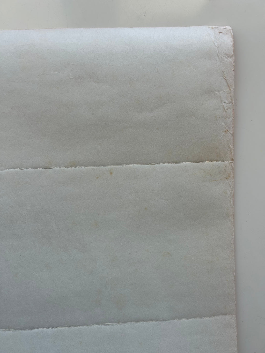 Close-up of a textured white paper with a slight brown discoloration.
