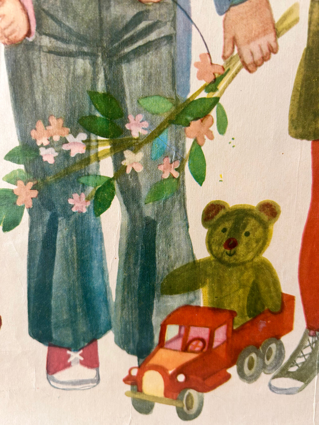 Illustration of a teddy bear in a red truck being pulled by a child with a flowered ribbon.