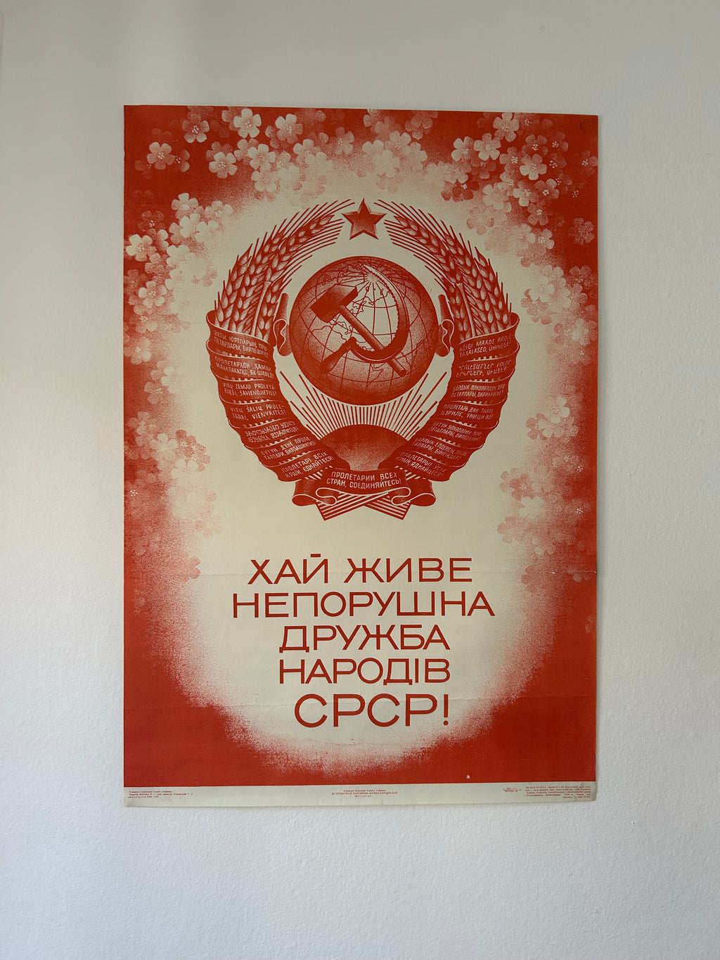 Vintage poster with a red and white emblem and text on a light gray background