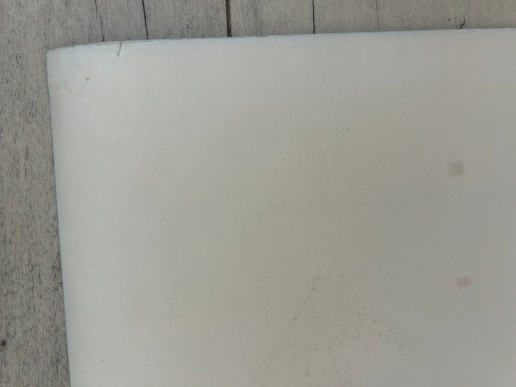 Close-up of a white cylindrical object on a textured surface
